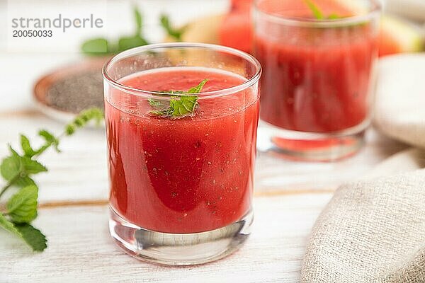 Wassermelonensaft mit Chiasamen und Minze in einem Glas auf einem weißen Holzhintergrund mit Leinenstoff. Gesundes Getränk Konzept. Seitenansicht  Nahaufnahme  selektiver Fokus