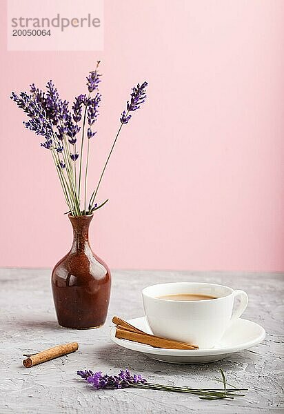 Lila Lavendel in Keramik Krug und eine Tasse Kaffee auf einem grauen und rosa Hintergrund. Morninig  Frühling  Mode Zusammensetzung. Seitenansicht  Nahaufnahme  selektiver Fokus