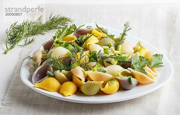 Conchiglie farbigen Nudeln mit frischen grünenGemüse auf einem Leinen Tischdecke auf weißem Holz Hintergrund. close up  selektiven Fokus