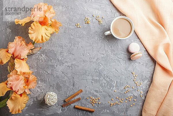 Orange Irisblüten und eine Tasse Kaffee auf einem grauen Betonhintergrund. Morninig  Frühling  Mode Zusammensetzung. Flachlage  Draufsicht  Kopierraum