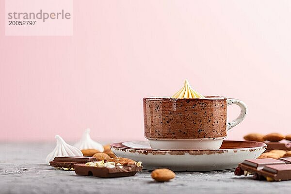 Tasse heiße Schokolade und Stücke von Milchschokolade mit Mandeln auf einem grauen und rosa Hintergrund. Seitenansicht  Nahaufnahme  selektiver Fokus  Kopierraum