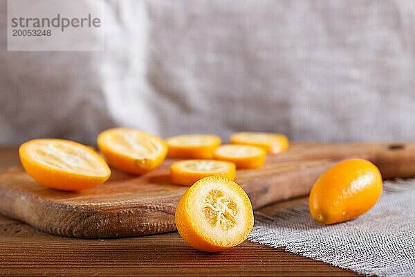 In Scheiben geschnittene Kumquats auf einem hölzernen Küchenbrett  Nahaufnahme  selektiver Fokus  Kopierraum