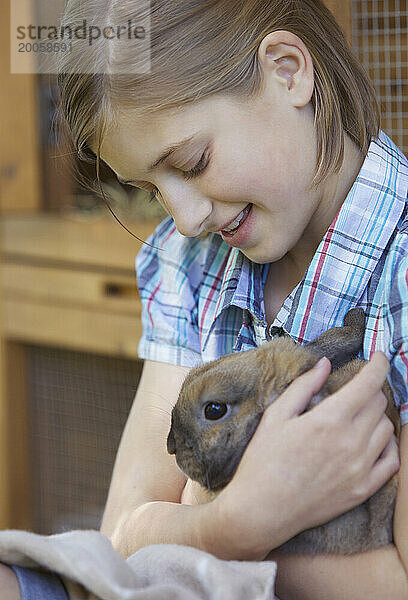 Nettes Mädchen  das braunes Kaninchen hält