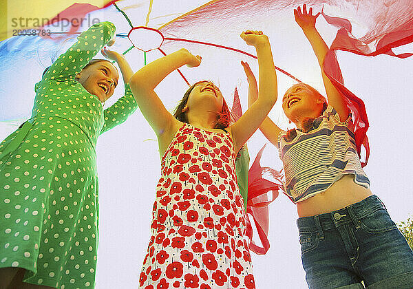 Kinder spielen unter dem Fallschirm