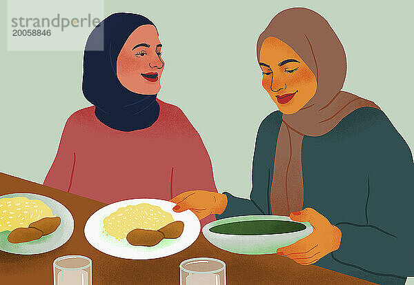 Fröhliche Freundinnen in Hijabs genießen das gemeinsame Abendessen am Tisch