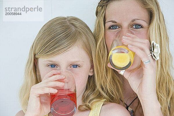 Frau und junges Mädchen trinken Saft