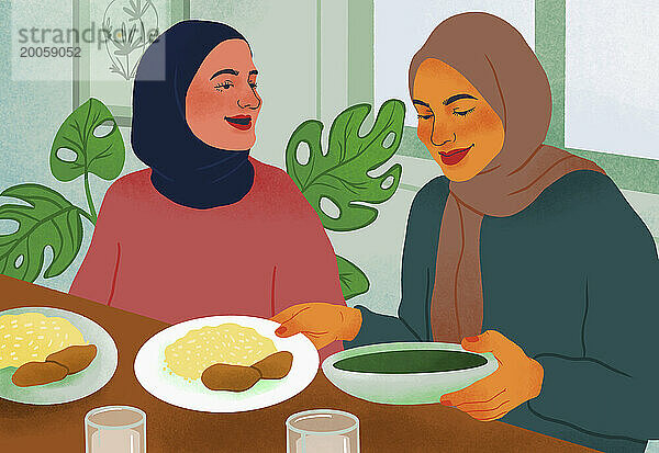 Freundinnen in Hijabs essen gemeinsam am Tisch