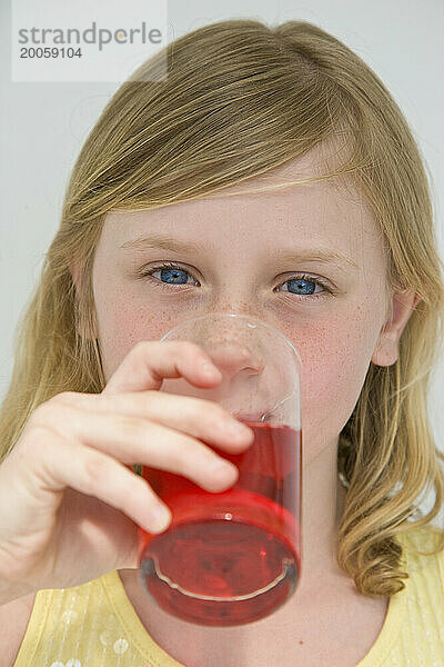 Junges Mädchen trinkt Cranberrysaft