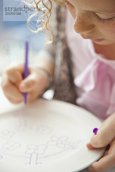 Mädchen zeichnet auf Keramikplatte