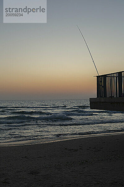 Angelrute am Rand des Balkons über dem Sonnenuntergang am Meeresstrand in der Abenddämmerung  Bat Yam  Israel