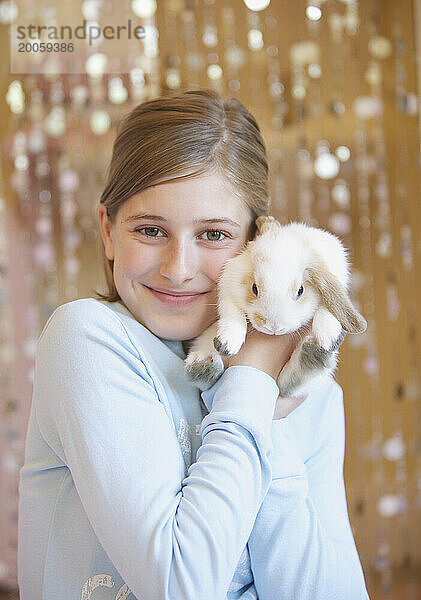 Mädchen hält weißes Kaninchen