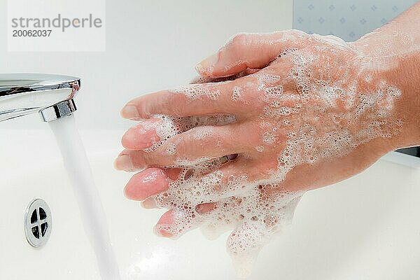 Eine Frau wäscht sich Wasser und Seife die Hände. Schutz vor Infektion der neuen Grippe
