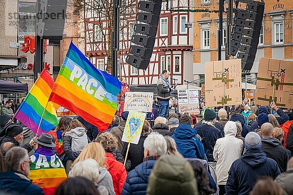 Eine Menschenmenge bei einer Versammlung  mit Friedensflagge und Transparenten  im Fokus Redner auf Bühne  Gegen Rechts Demo  Nagold  Schwarzwald  Deutschland  Europa