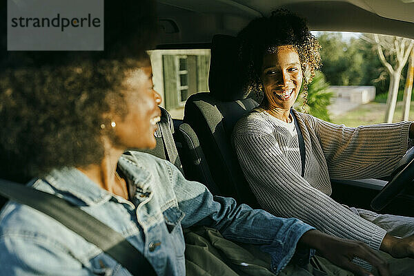 Glückliche junge Frauen sitzen im Auto