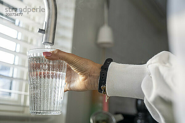 Dame füllt ihr Glas mit frischem  sauberem Wasser