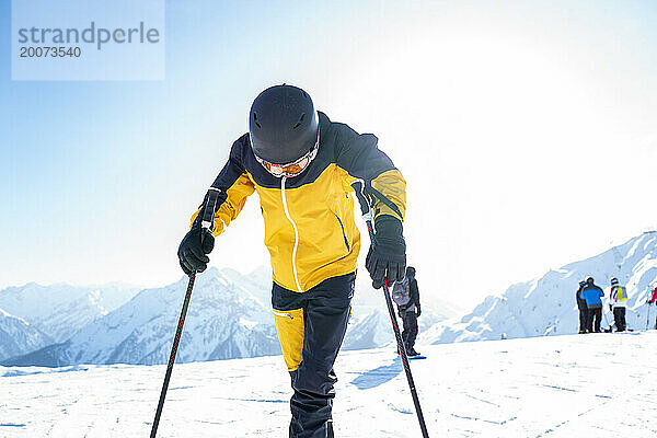 Junge Freunde auf dem Gipfel eines Schweizer Berges  bereit  die Pisten hinunterzufahren. Winterliches schönes Licht