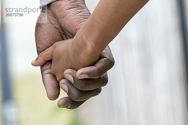 Mutter und Sohn gemischter Abstammung halten Händchen zusammen. Bedingungslose Liebe