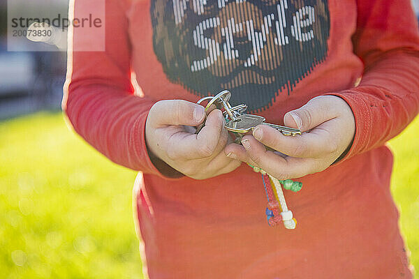 Kleiner Junge hält den Schlüssel zu seinem Haus im Park