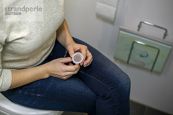 Woman sitting on the toilet with her sanitary health product health menstruation period