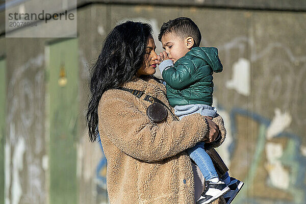 Mutter und Sohn umarmen sich im Park.