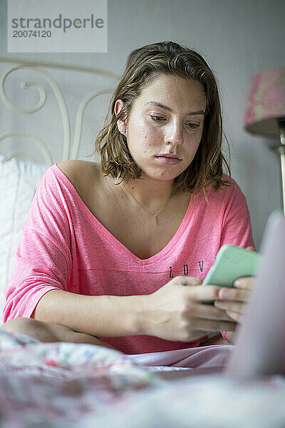 Teenager-Mädchen lernt im Bett mit ihrem Laptop