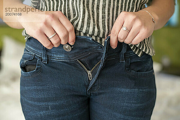 Frau probiert Jeans an und passt aufgrund ihrer Menstruation nicht hinein