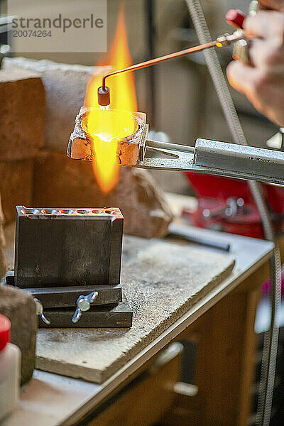 Uhrmacher repariert eine klassische Uhr und Schmuck  authentischer Arbeitsplatz. Verwenden Sie kleine Werkzeuge für Reparaturen  die in einem kleinen Ofen erhitzt werden