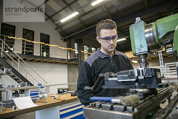 Junger Maschinenbauingenieur arbeitet in einer Fabrik an Stahlmaschinen