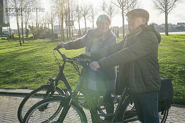 Älteres Paar macht eine Radtour  um im Ruhestand fit und gesund zu bleiben. Mit dem Telefon nach Hause navigieren