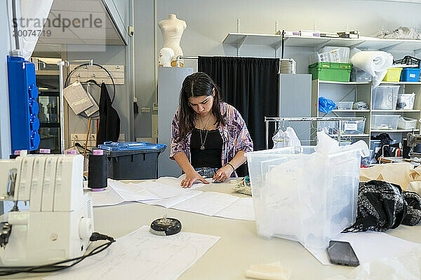 Modedesignerin arbeitet in ihrer Werkstatt an Stoffdesigns. Konzentration auf Muster und Design