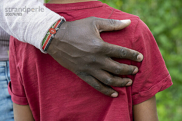 Nigerianischer Vater und Sohn halten sich an den Händen. Bedingungslose Liebe