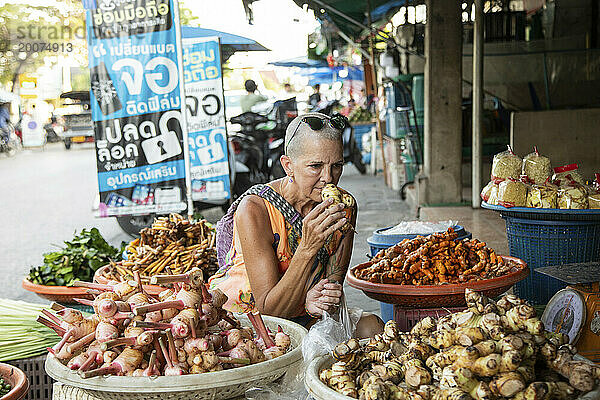 Alleinreisende Frau mittleren Alters auf einem Gewürzmarkt im Norden Thailands