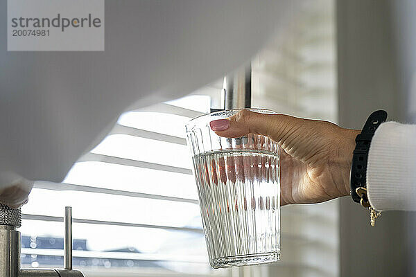 Dame füllt ihr Glas mit frischem  sauberem Wasser