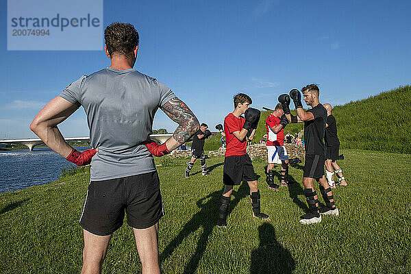 Junge Männer halten sich durch Kickboxen fit. Gruppe von Jungs gesund und fit