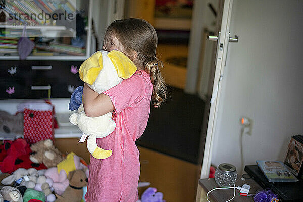 Junges Mädchen ist schüchtern und umarmt ihre Teddys  um sich zu trösten