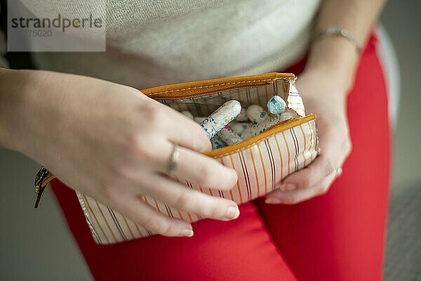 Frau hält ihre monatlichen Menstruationsgesundheitsprodukte  Tasse und Tampon in der Hand
