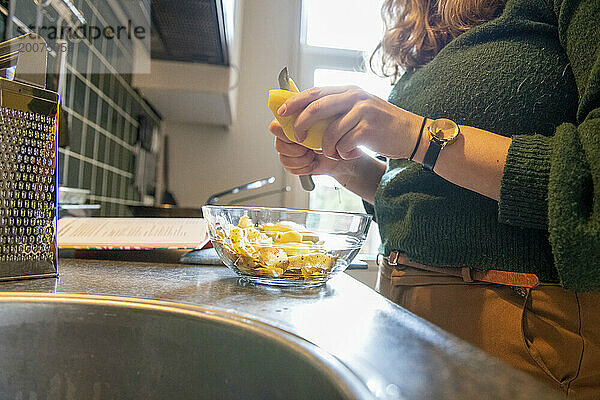 Attraktive alleinstehende Frau  die sich das Mittagessen zubereitet. Gemüse hacken für eine gesunde Moderne