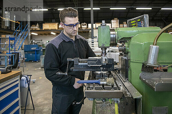 Junger Maschinenbauingenieur arbeitet in einer Fabrik an Stahlmaschinen