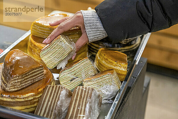 African American woman Selecting cakes at a supermarket