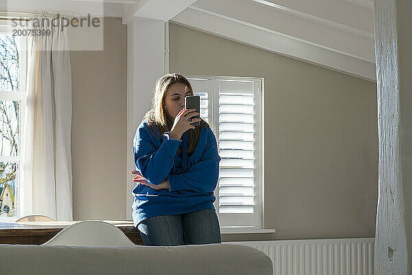 mürrischer Teenager  der sich auf ihr Telefon konzentriert