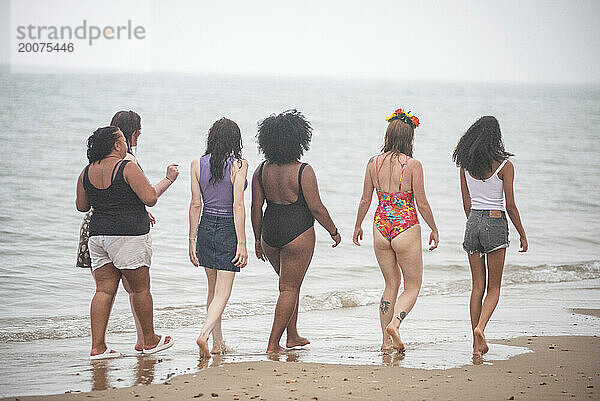 Eine gemischte Gruppe Freundinnen  die Spaß am Strand haben.