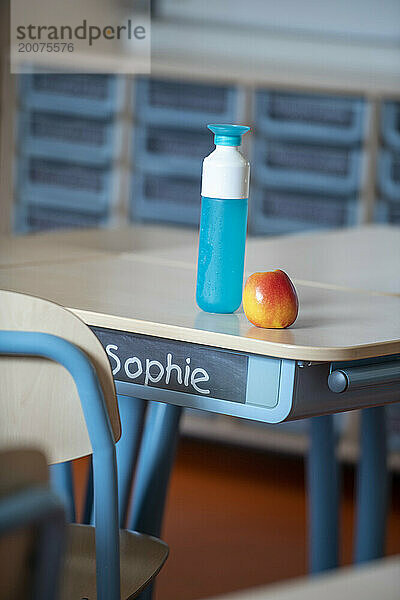 Wasser und Apfel auf dem Schreibtisch in der Schule