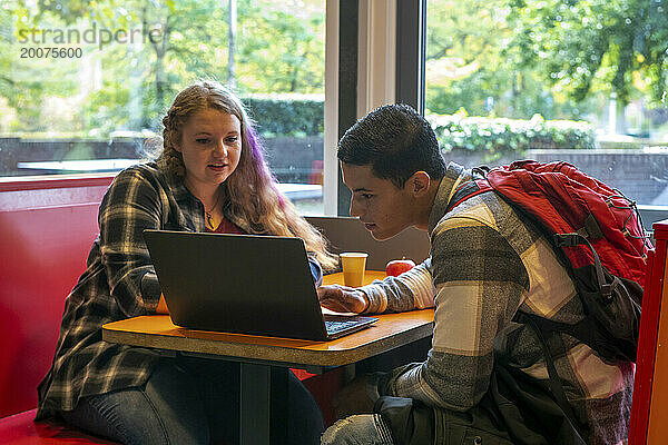 Schüler und Lehrer arbeiten an einem Laptop