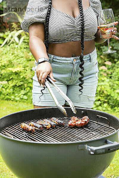 Frauen genießen eine sommerliche Grillparty im Garten und kochen und essen draußen