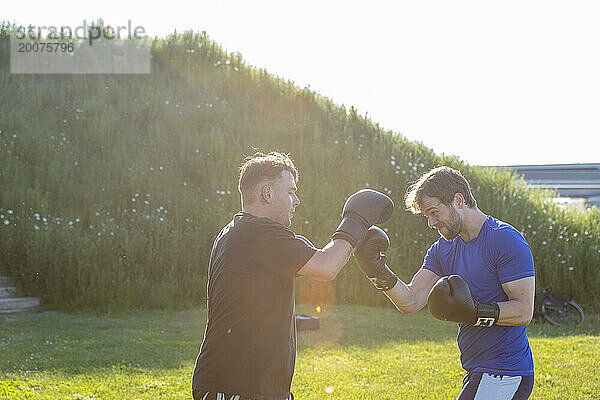 Junge Männer halten sich durch Kickboxen fit. Gruppe von Jungs gesund und fit