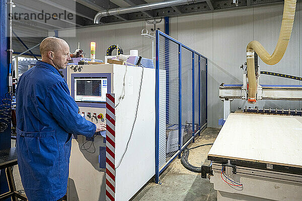 Arbeiter in einer großen CNC-Maschine in einer Metallfabrik