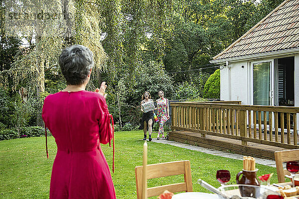 Freunde und Familie kommen zu einer Sommergartenparty