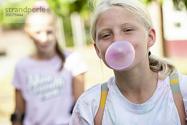 Junges Mädchen mit Kaugummi  Seifenblasen