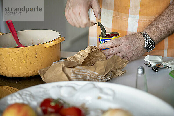 Erwachsener Mann bereitet in seiner modernen Küche Hackfleisch für eine Lasagne zu