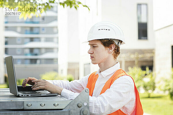 Ingenieur mit Helm arbeitet außerhalb des neuen Gebäudes